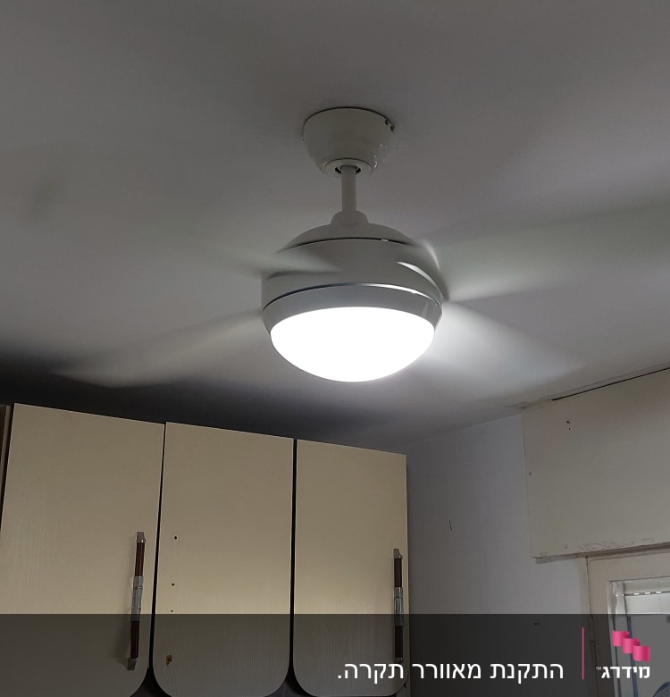 מאוורר תקרה עם תאורה דולקת בחדר